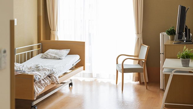 A room inside of an assisted living facility with a hospital bed.