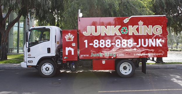 A branded Junk King dump truck parked on the street.