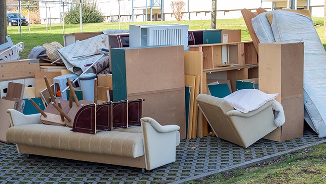 A group of old bookcases and furniture sitting outside.