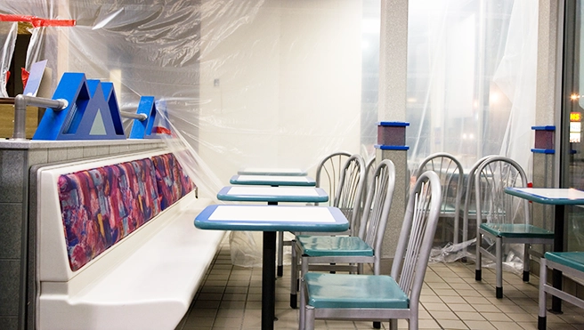 A vacant restaurant lobby with chairs and tables.