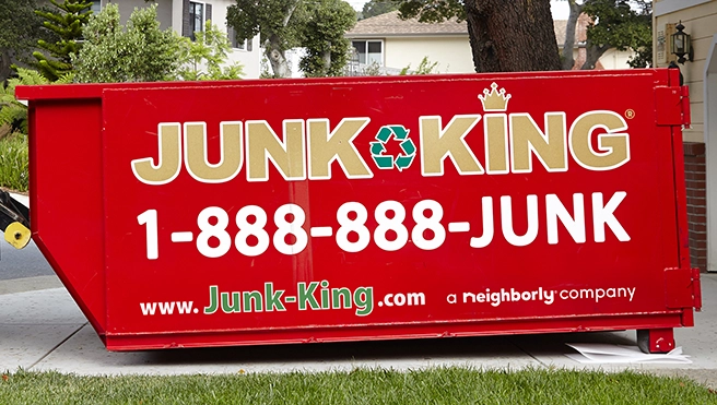 Red dumpster bin with Junk King branding on outside.