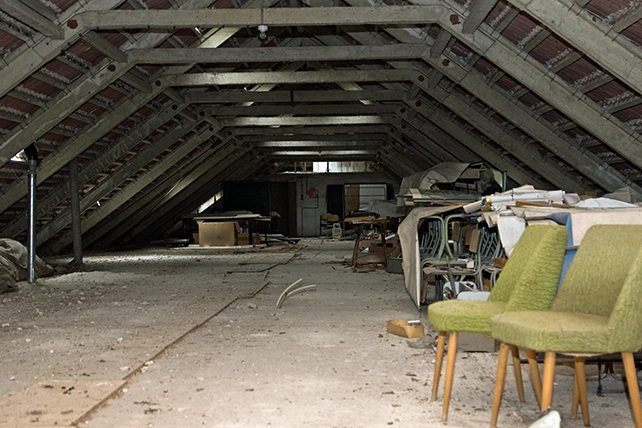 A dark attic with some miscellaneous furniture.