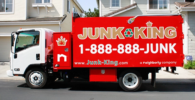 Red Junk King truck parked in front of a home.