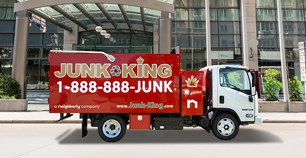 Junk King dump truck in front of a business.