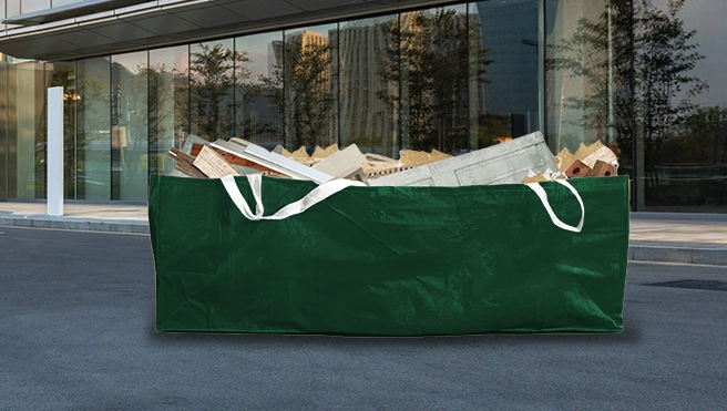 Green dumpster bag outside of a commercial building.