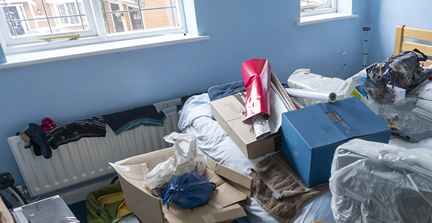 A room with blue painted walls full of various types of junk.