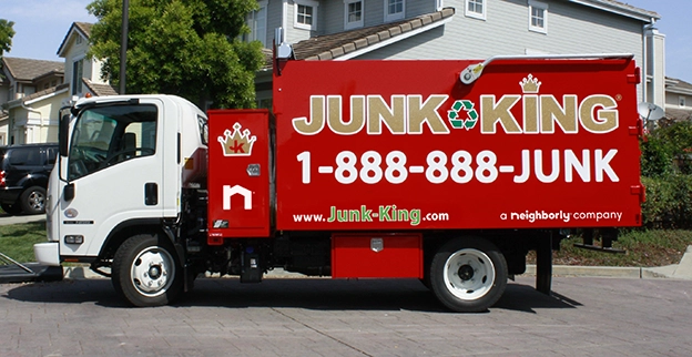 Red dump truck with Junk King contact information on the side.