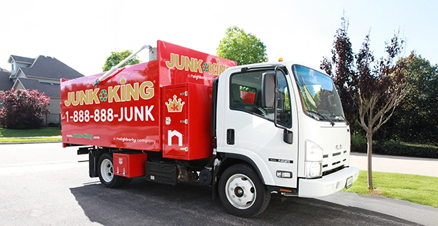 Red Junk King dump truck parked in a residential area.