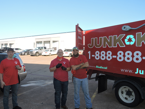 2 Junk King Team members and truck parked outside commercial building
