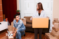 Man and woman packing boxes in apartment