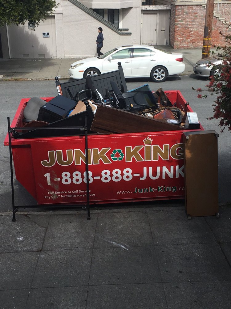 Junk King Dumpster filled with furniture and debris