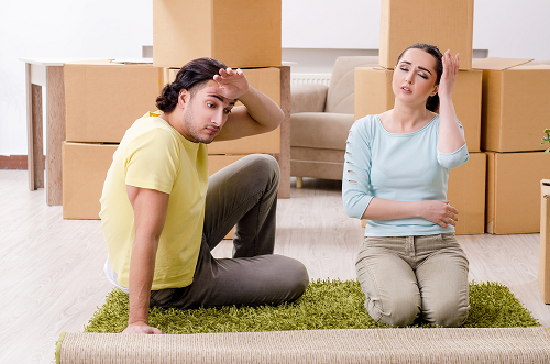 male and female sitting on rug with boxes in the background