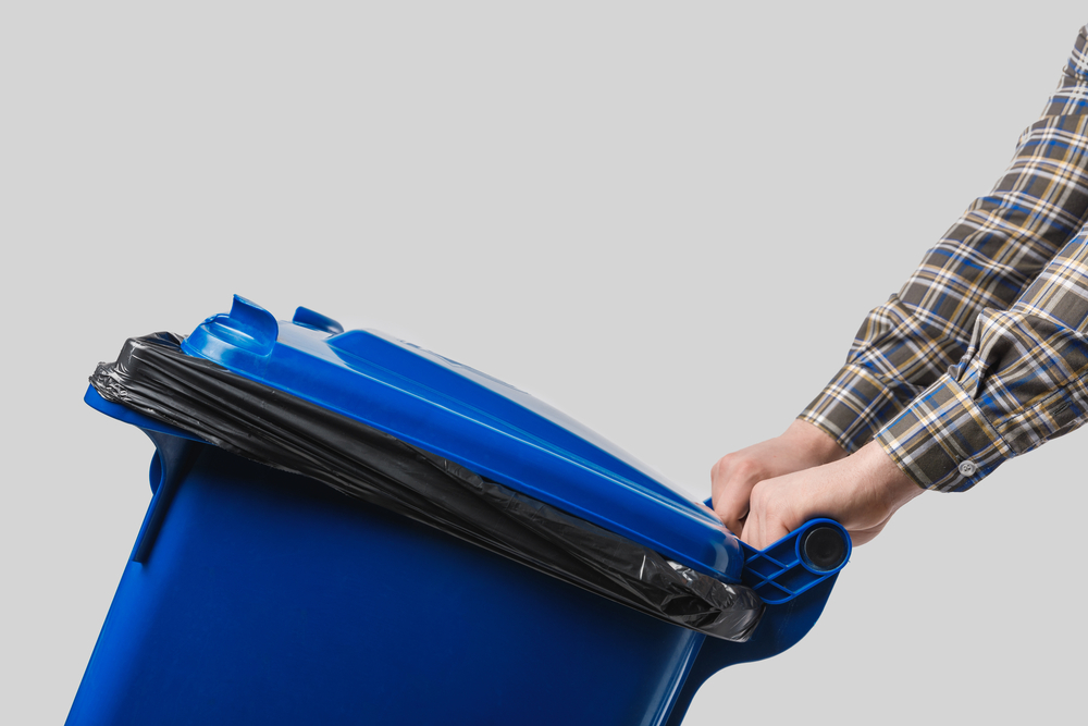 Man moving garbage bin