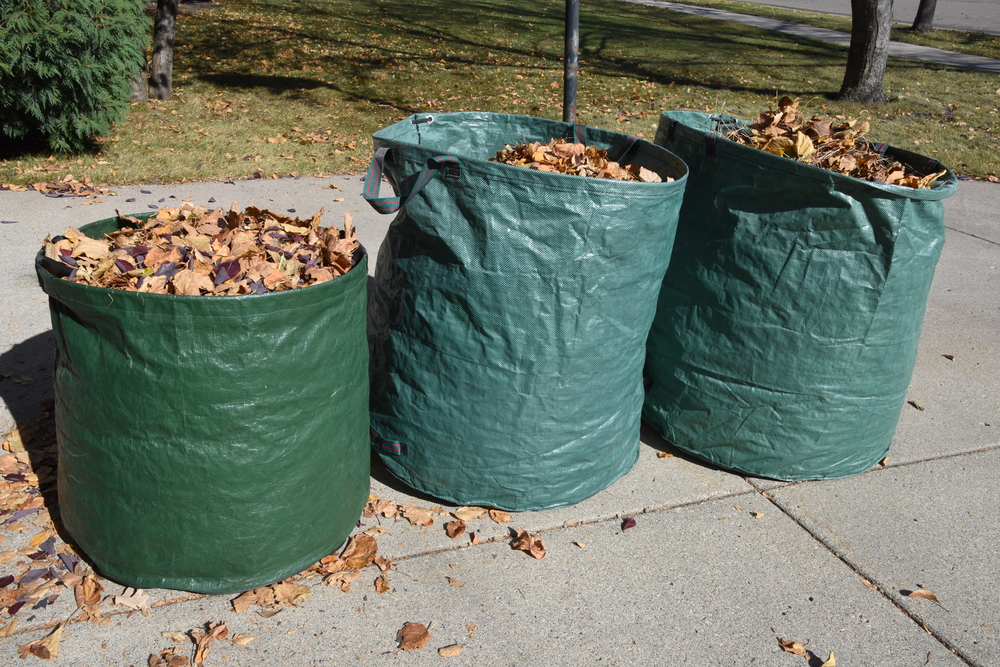 3 waste bags filled with yard waste.