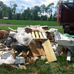 commercial debris in a pile and a the back of a red junk king truck