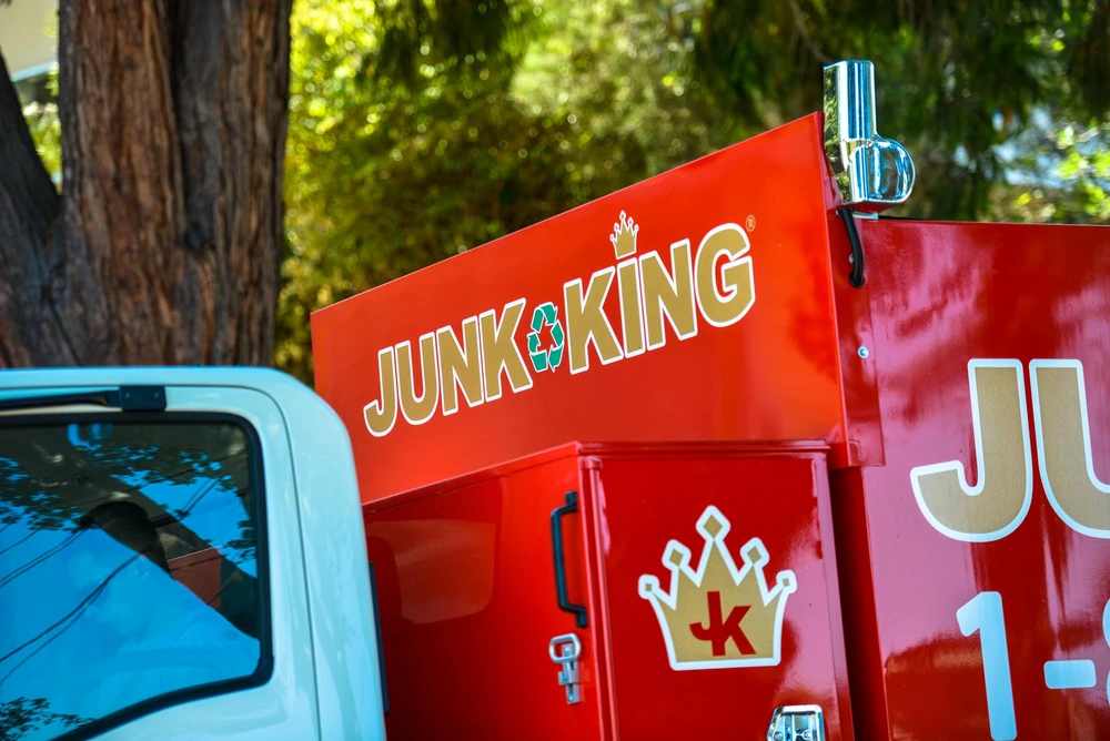 Junk King crew removing an old hot tub from a backyard in San Bruno