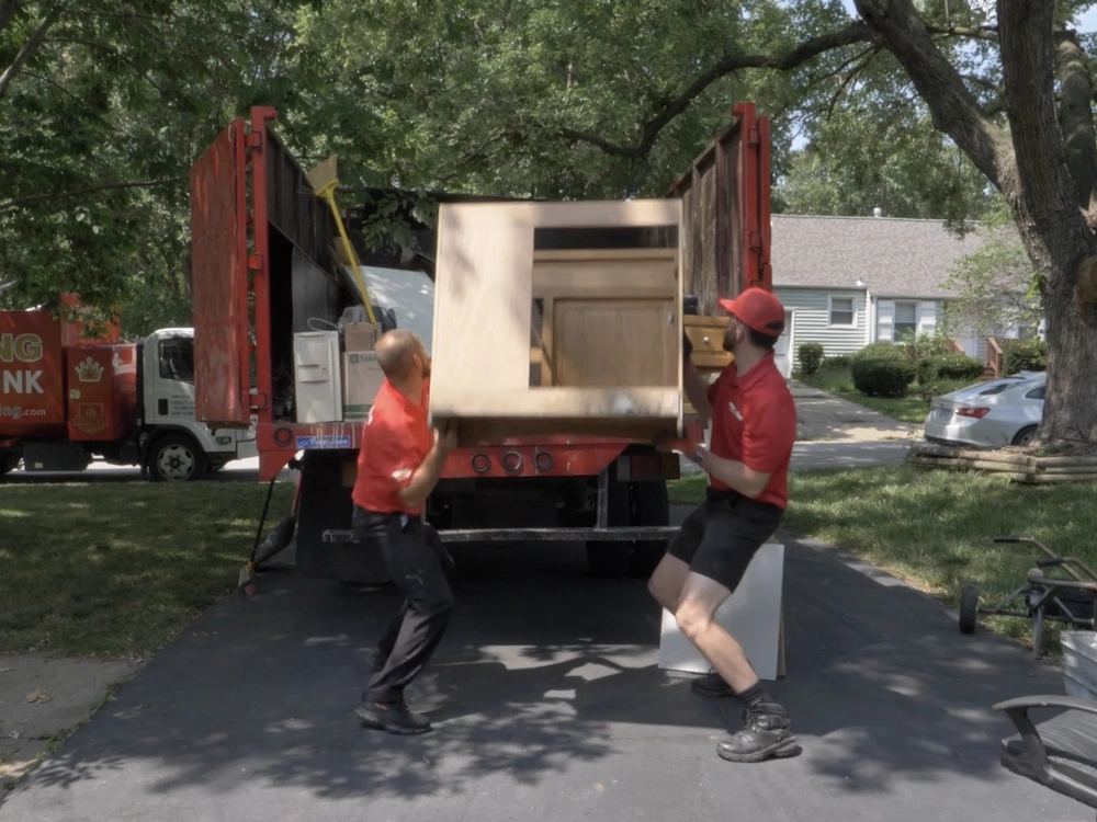 Furniture removal team hauling away old couch in Redwood City