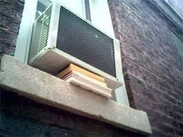 An air conditioning unit sits on a windowsill.