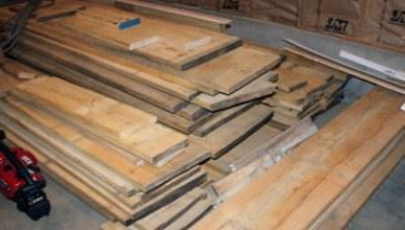 Stack of wooden boards in a workshop or storage area.